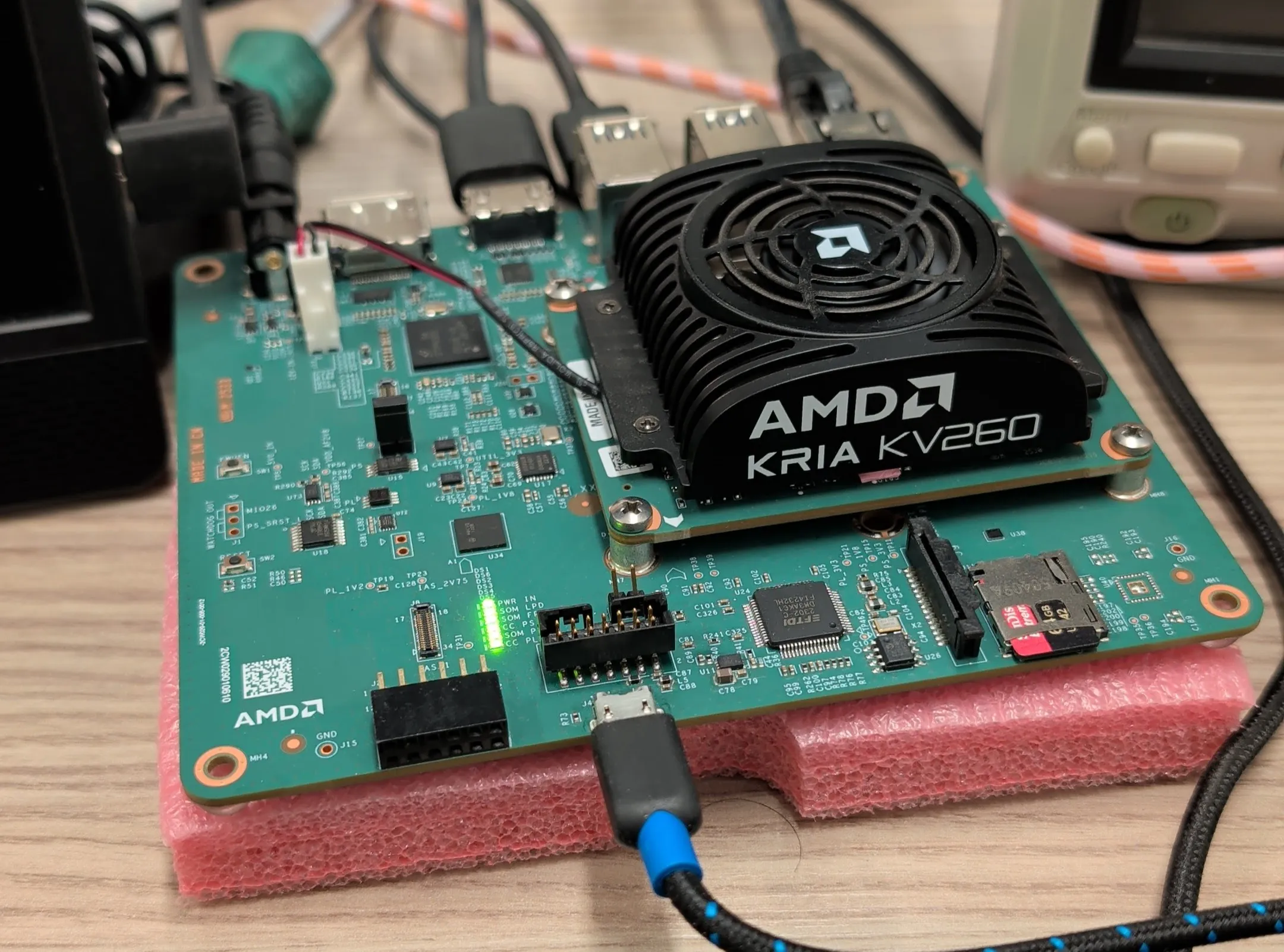 The AMD Kria KV260 on the bench. The language model lives under that fan.
